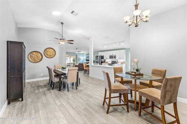 dining area featuring an inviting chandelier, track lighting, vaulted ceiling, and light hardwood / wood-style flooring