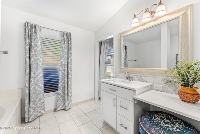 bathroom with lofted ceiling, vanity, and a bathtub