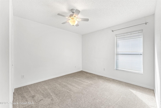 carpeted empty room with ceiling fan and a textured ceiling