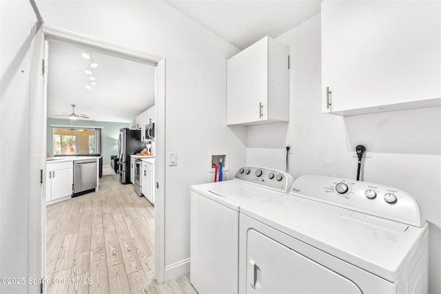 clothes washing area featuring washer and dryer, cabinets, ceiling fan, and light wood-type flooring