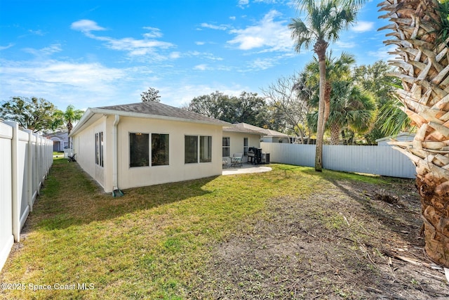 back of house featuring a patio area and a lawn