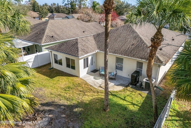 rear view of house featuring central AC, a patio area, and a lawn