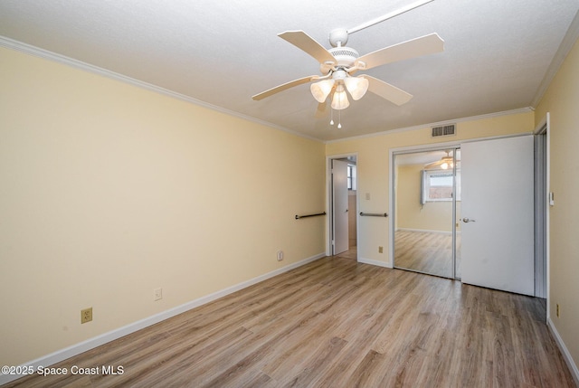 unfurnished bedroom with crown molding, ceiling fan, light hardwood / wood-style floors, and a closet