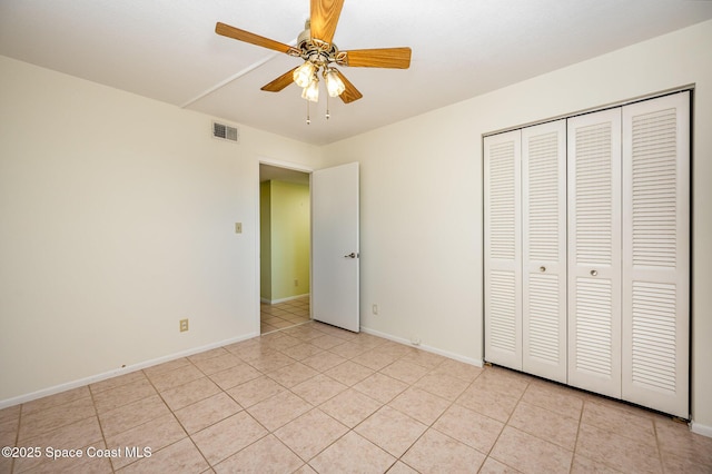 unfurnished bedroom with light tile patterned floors, ceiling fan, and a closet