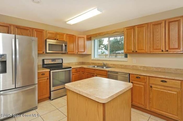 kitchen with stainless steel appliances, a kitchen island, sink, and light tile patterned floors