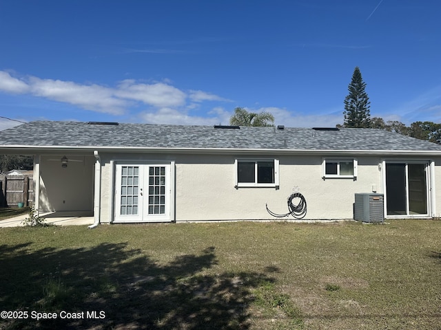 back of property with a patio, a yard, central air condition unit, and french doors