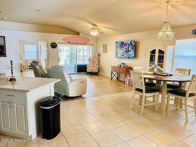 dining space featuring lofted ceiling, light tile patterned floors, and ceiling fan