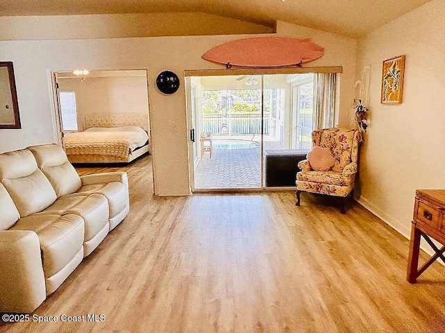 living room featuring lofted ceiling and light hardwood / wood-style flooring