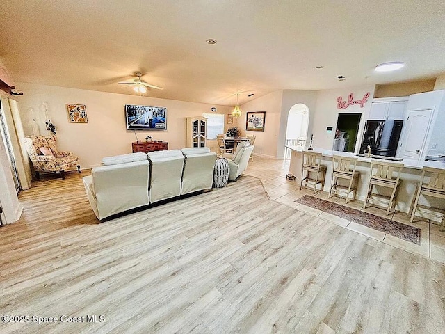 living room featuring ceiling fan, a textured ceiling, and light wood-type flooring