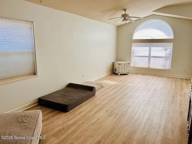 empty room with vaulted ceiling, wood-type flooring, and ceiling fan