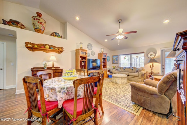 dining area with wood-type flooring, high vaulted ceiling, and ceiling fan