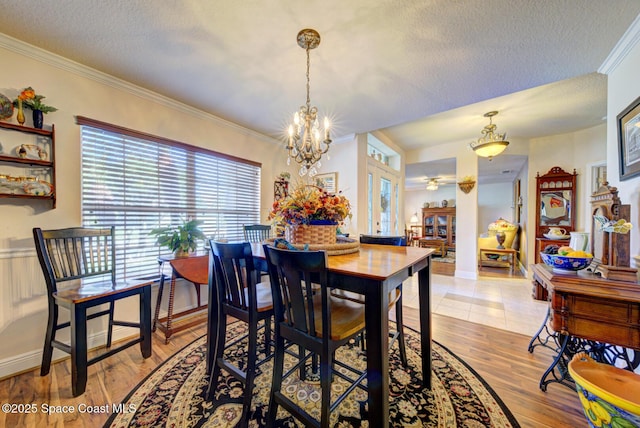 dining area featuring french doors, ornamental molding, light hardwood / wood-style flooring, and a textured ceiling