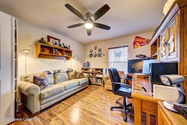 home office with ceiling fan, a textured ceiling, and light wood-type flooring