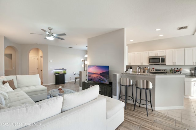 living room featuring ceiling fan and light hardwood / wood-style floors