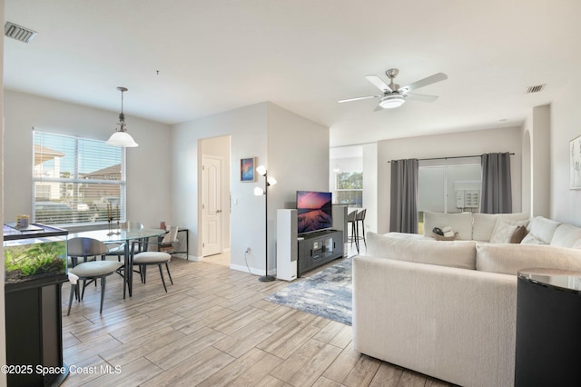 living room featuring ceiling fan and light wood-type flooring