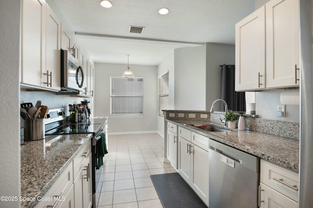 kitchen featuring light stone counters, stainless steel appliances, sink, and white cabinets