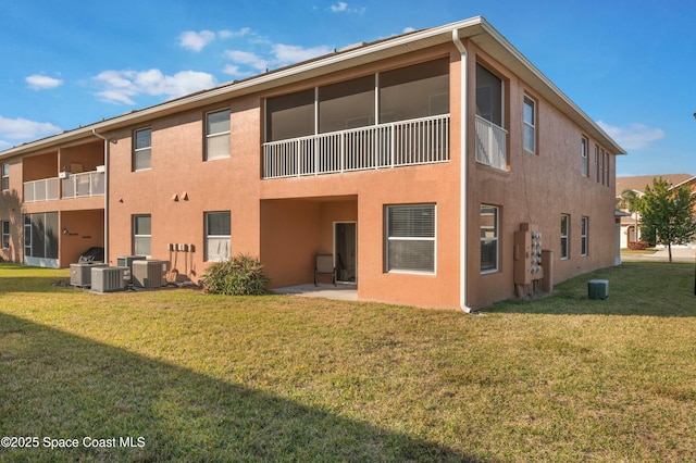 back of property featuring central AC unit and a yard