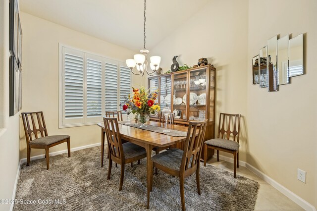 dining space featuring vaulted ceiling, a chandelier, and carpet