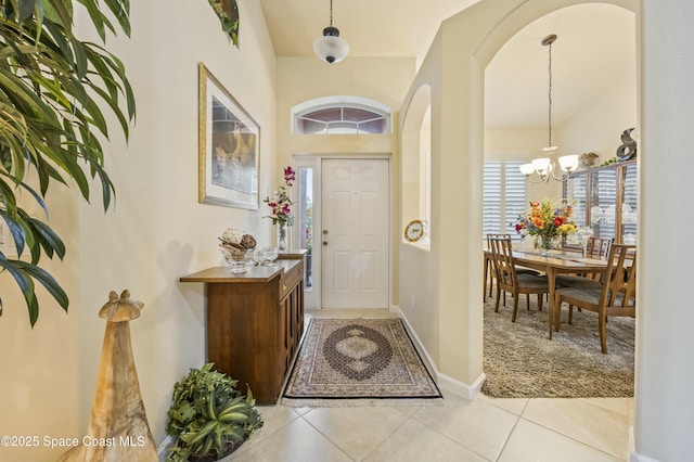 foyer entrance featuring light tile patterned floors and a notable chandelier