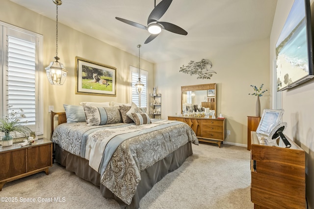 carpeted bedroom featuring multiple windows and ceiling fan