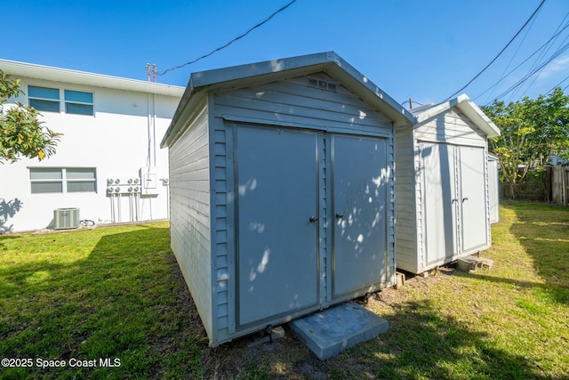 view of outbuilding featuring a yard and central air condition unit