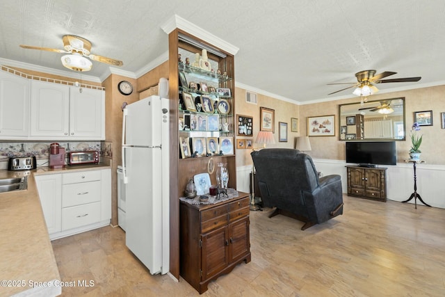 kitchen with white cabinetry, white appliances, light hardwood / wood-style flooring, and ornamental molding