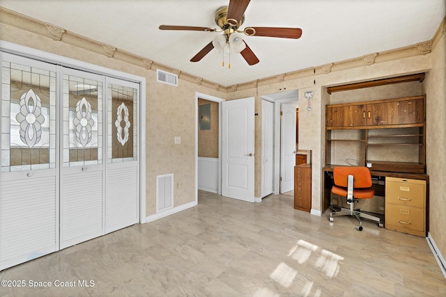unfurnished office featuring a ceiling fan and baseboards