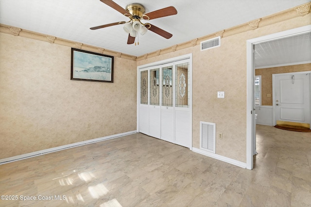 unfurnished bedroom featuring crown molding, baseboards, a closet, a ceiling fan, and wallpapered walls