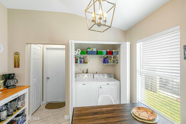 laundry area featuring a notable chandelier, washing machine and dryer, and a healthy amount of sunlight