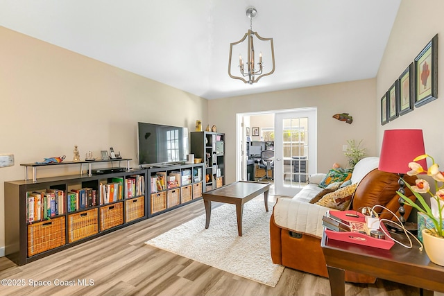 living room featuring a notable chandelier and light hardwood / wood-style floors