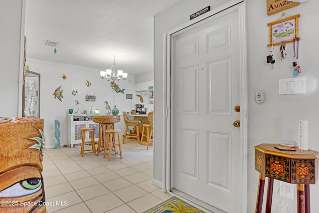 entrance foyer with light tile patterned floors and a chandelier