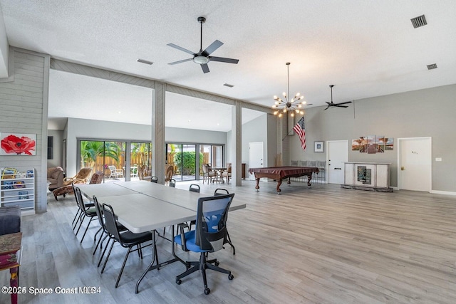 playroom featuring billiards, a textured ceiling, light wood-type flooring, ceiling fan with notable chandelier, and a high ceiling