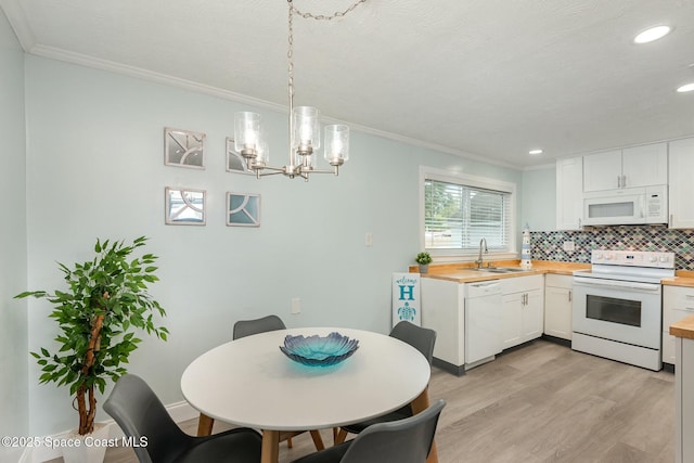 kitchen featuring sink, decorative light fixtures, white appliances, decorative backsplash, and white cabinets