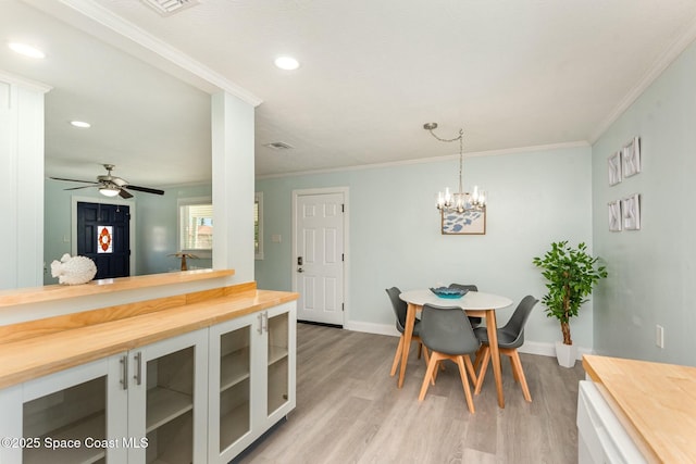 dining area featuring ornamental molding, ceiling fan, and light hardwood / wood-style flooring