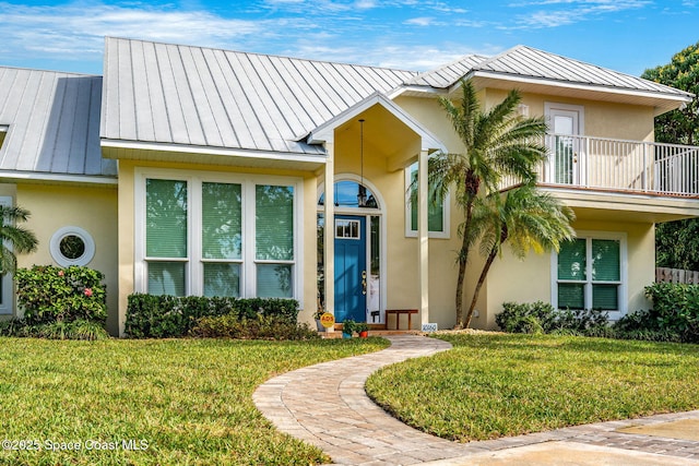 view of front of home with a balcony and a front yard