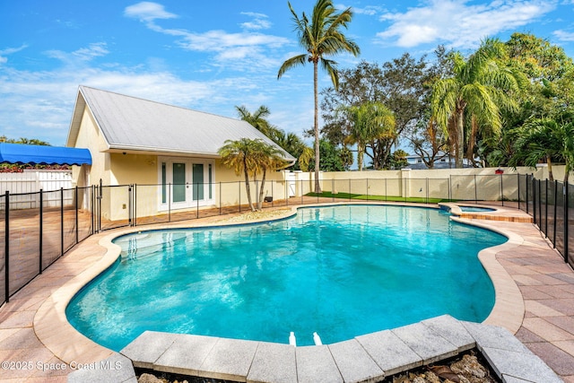 view of swimming pool featuring an in ground hot tub and french doors