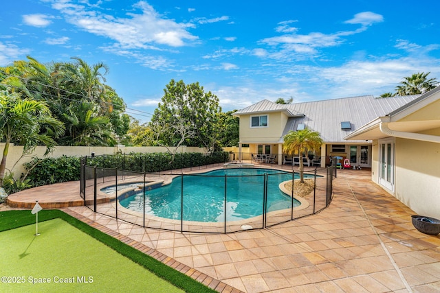 view of swimming pool featuring a jacuzzi and a patio area