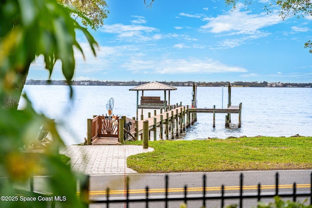 dock area with a water view and a yard