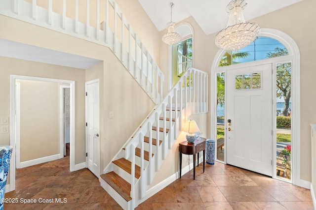 foyer entrance with a towering ceiling and a chandelier