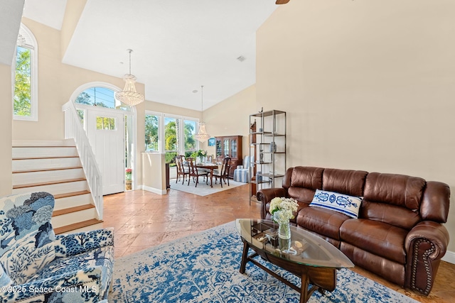 living room with a notable chandelier, high vaulted ceiling, and light tile patterned floors