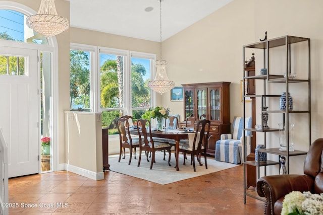 dining area featuring high vaulted ceiling and a chandelier