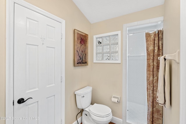 bathroom featuring toilet and a tile shower