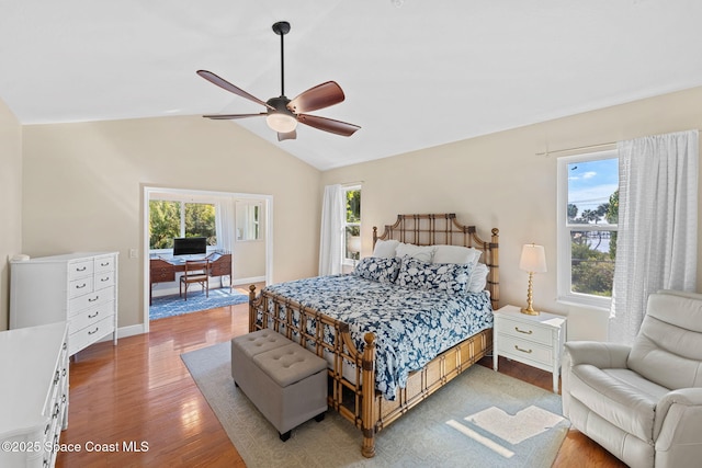 bedroom featuring multiple windows, wood-type flooring, and lofted ceiling