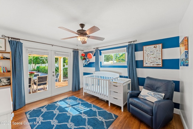 bedroom featuring multiple windows, hardwood / wood-style flooring, access to outside, and french doors