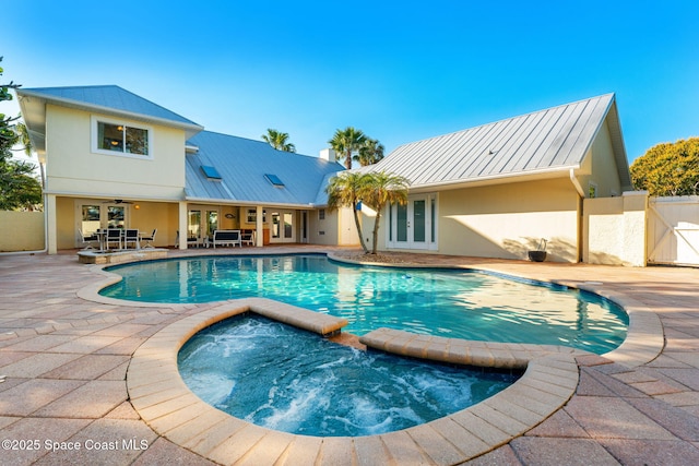 view of pool with a patio area, french doors, ceiling fan, and an in ground hot tub