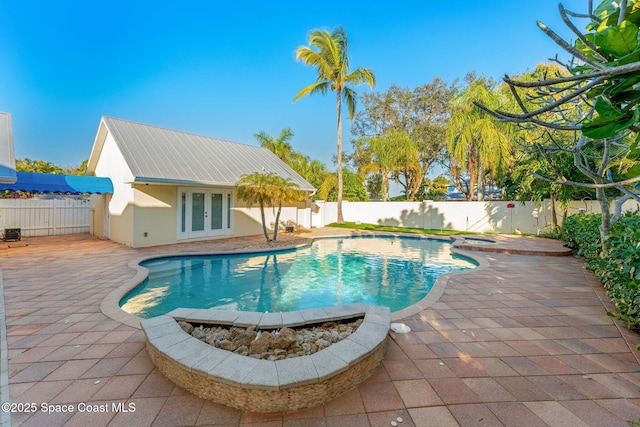 view of swimming pool featuring french doors and a patio