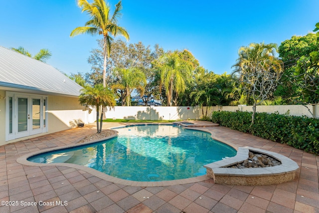 view of swimming pool featuring french doors, a jacuzzi, and a patio