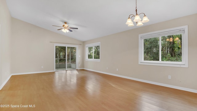 unfurnished room with vaulted ceiling, ceiling fan with notable chandelier, and light hardwood / wood-style floors