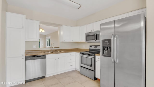 kitchen with sink, white cabinetry, hanging light fixtures, light tile patterned floors, and appliances with stainless steel finishes