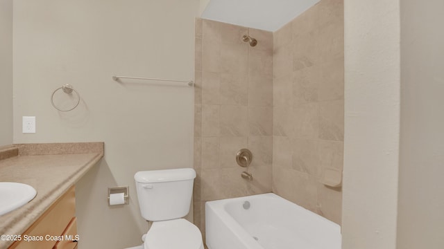 full bathroom featuring tiled shower / bath, vanity, and toilet